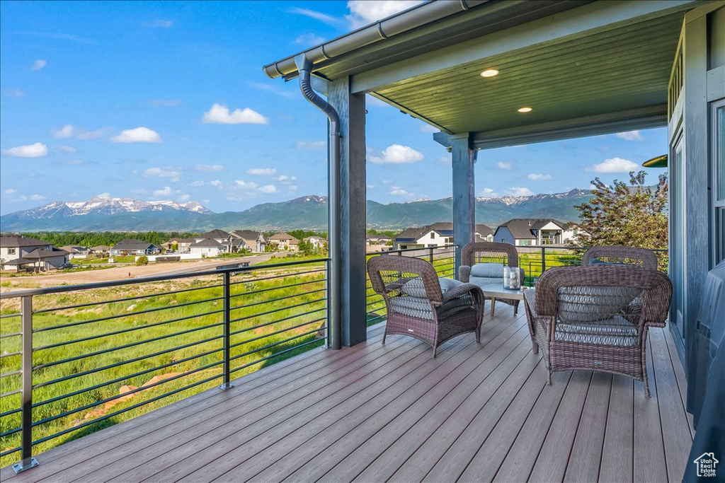 Wooden terrace featuring a mountain view and a yard