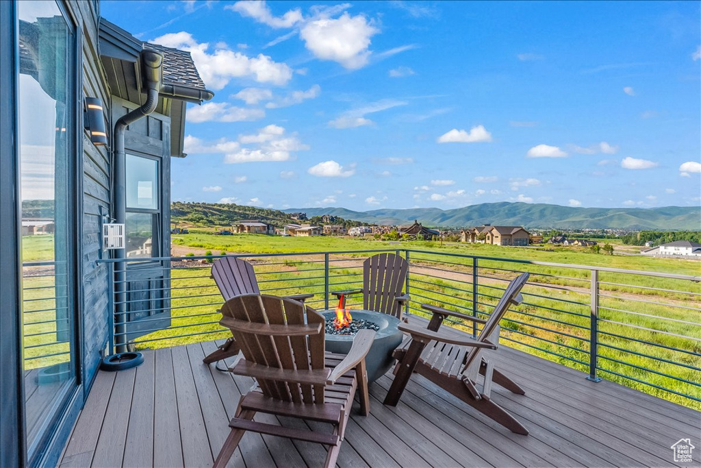 Wooden deck with a mountain view and a yard