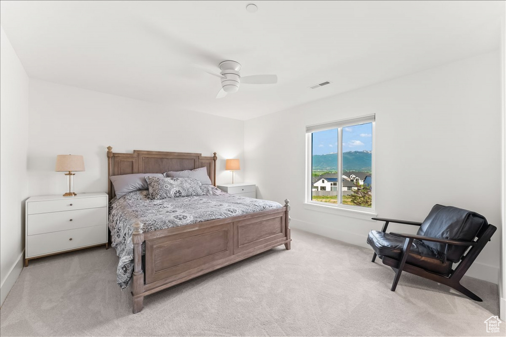 Carpeted bedroom featuring ceiling fan