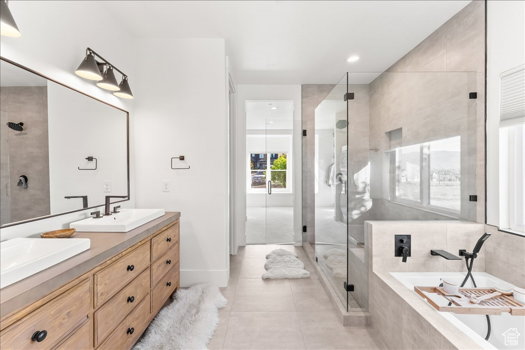 Bathroom with tile floors, dual vanity, and separate shower and tub