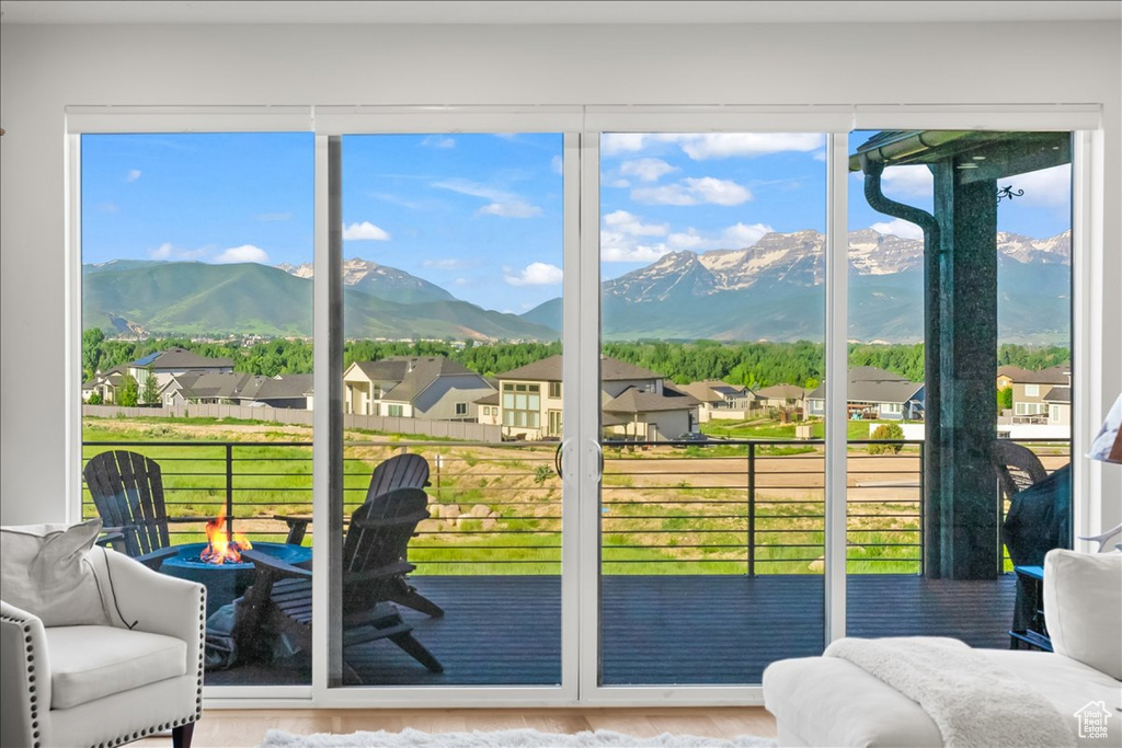 Doorway to outside with a mountain view, plenty of natural light, and hardwood / wood-style floors