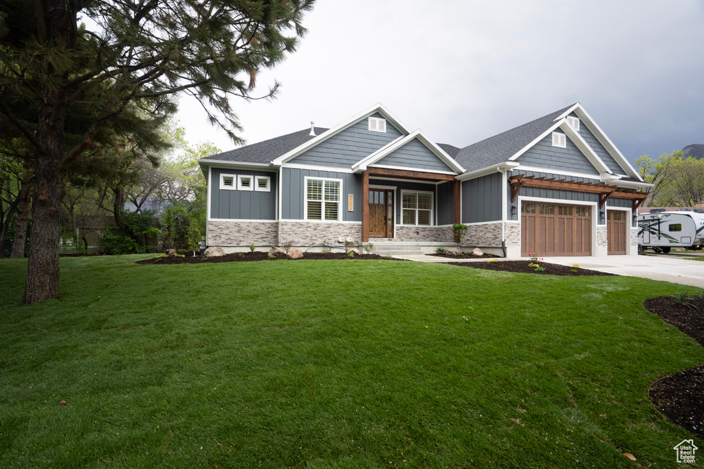 Craftsman house with a front lawn and a garage