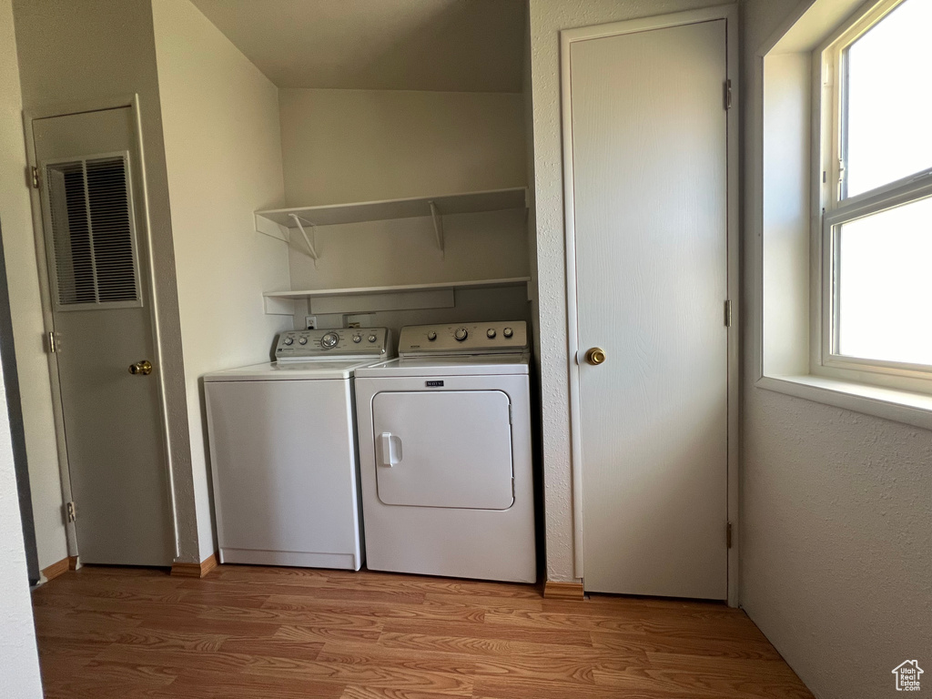 Laundry room featuring hardwood / wood-style floors and separate washer and dryer