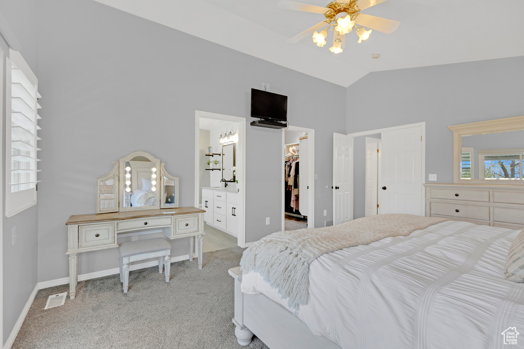 Bedroom featuring ensuite bath, ceiling fan, light carpet, and a closet