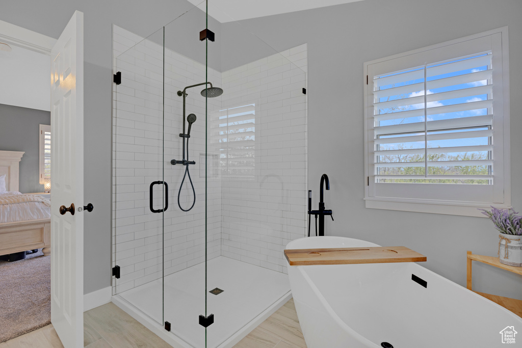 Bathroom with plus walk in shower and hardwood / wood-style flooring