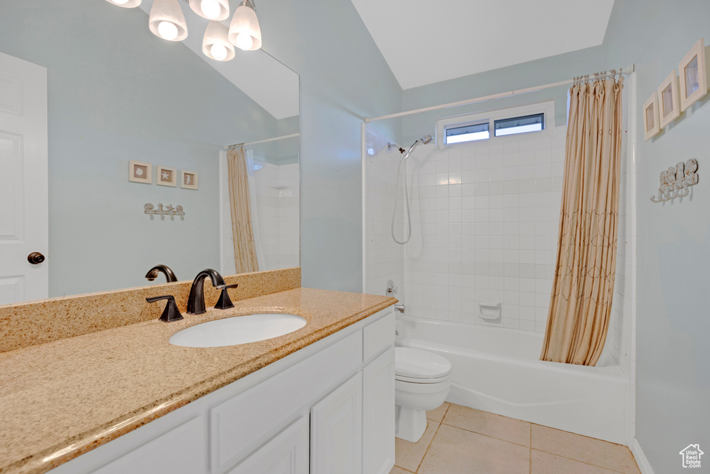 Full bathroom with tile floors, shower / bathtub combination with curtain, oversized vanity, toilet, and lofted ceiling