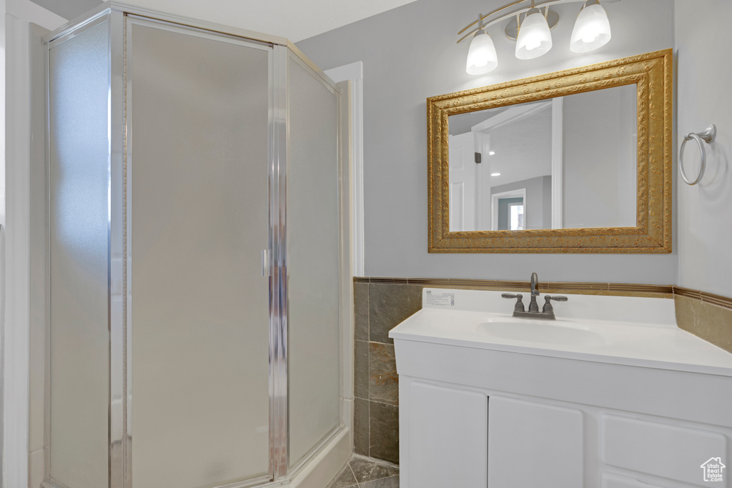Bathroom featuring vanity and a shower with door