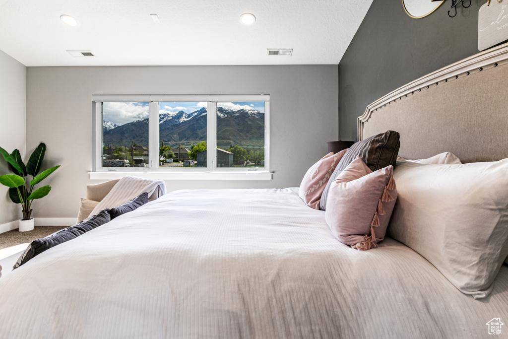 Carpeted bedroom with a mountain view and multiple windows