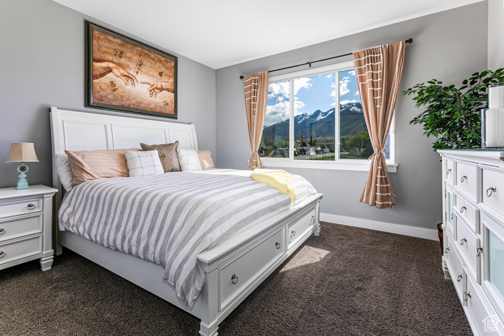 Bedroom with a mountain view and dark carpet