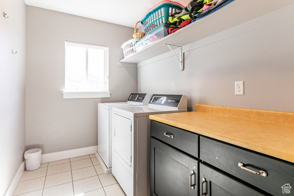 Washroom with cabinets, light tile floors, and separate washer and dryer