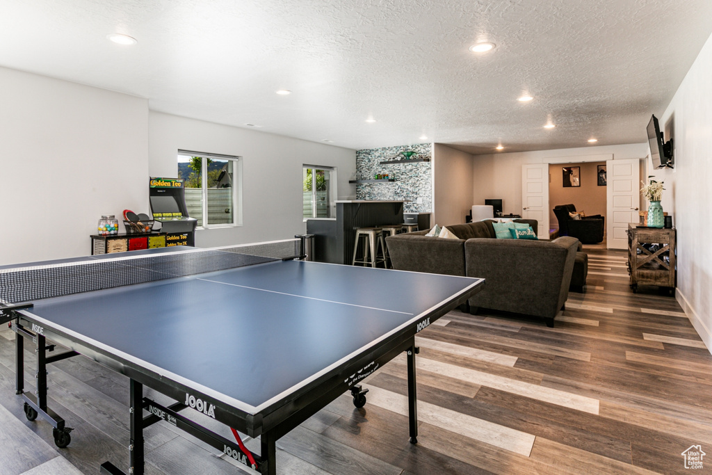 Game room with dark hardwood / wood-style flooring and a textured ceiling