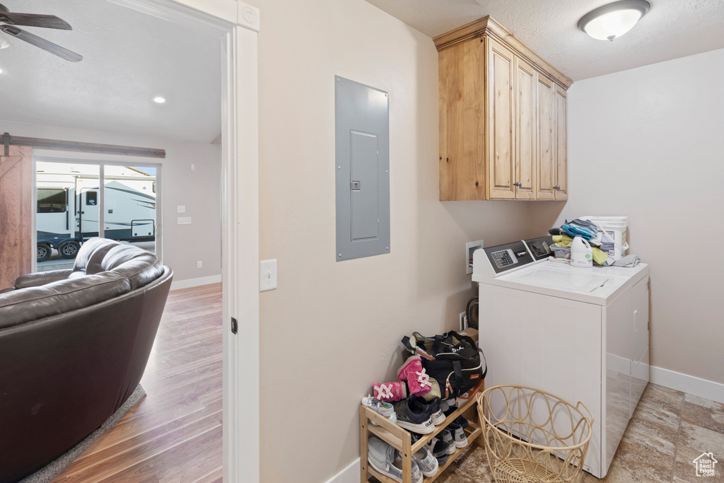 Washroom with washing machine and dryer, light hardwood / wood-style flooring, cabinets, ceiling fan, and washer hookup