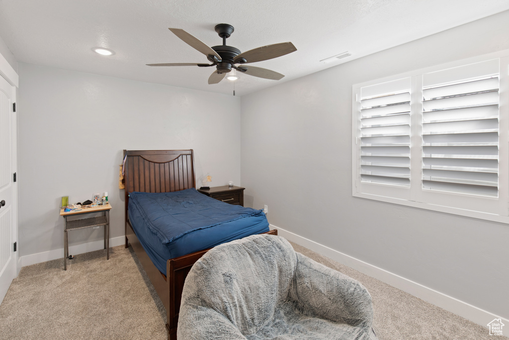 Carpeted bedroom featuring ceiling fan