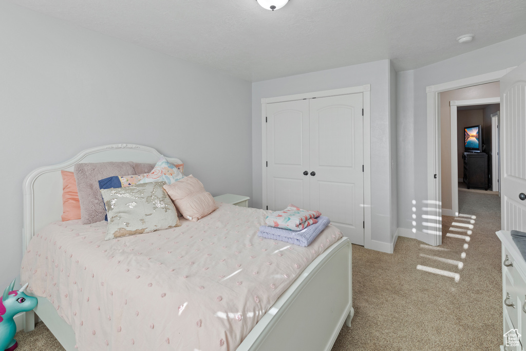 Carpeted bedroom featuring a closet