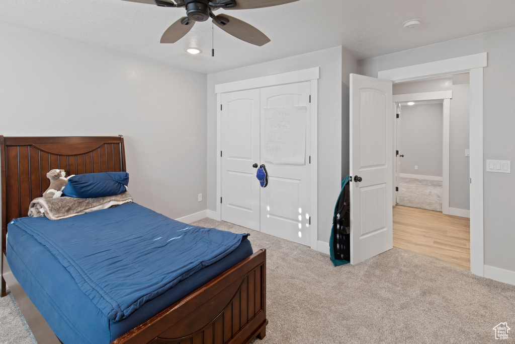 Bedroom featuring a closet, light hardwood / wood-style floors, and ceiling fan