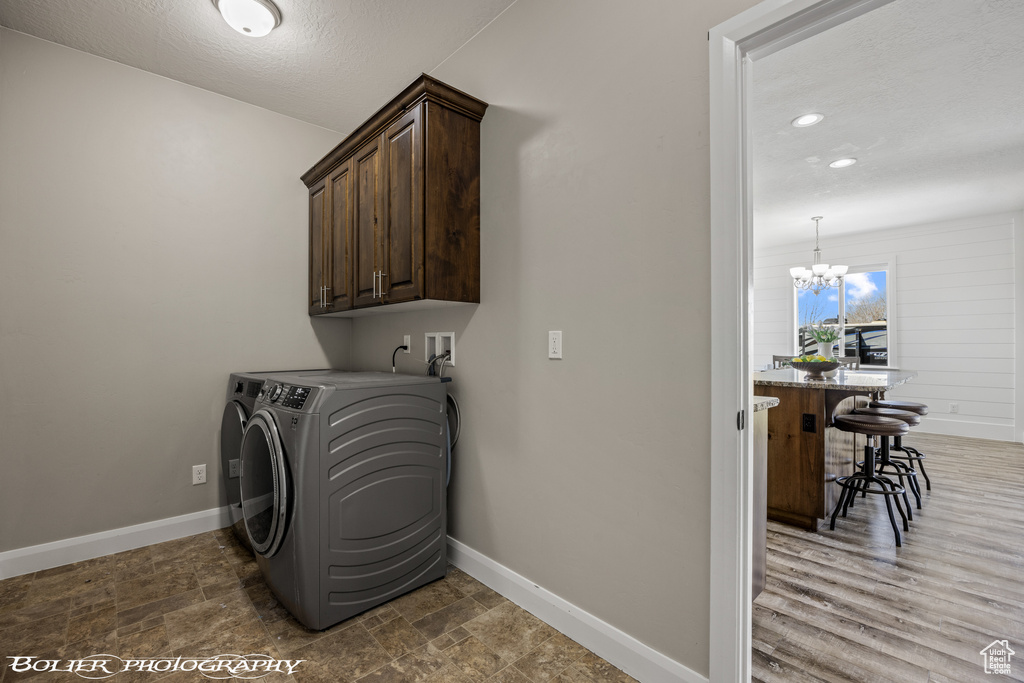 Laundry room with cabinets, separate washer and dryer, washer hookup, hardwood / wood-style floors, and a chandelier