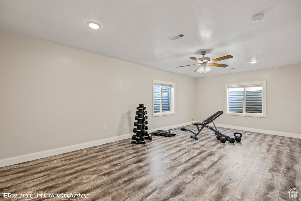 Workout area with wood-type flooring and ceiling fan