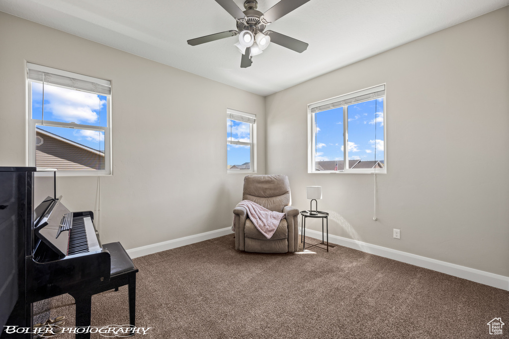 Living area featuring ceiling fan and carpet