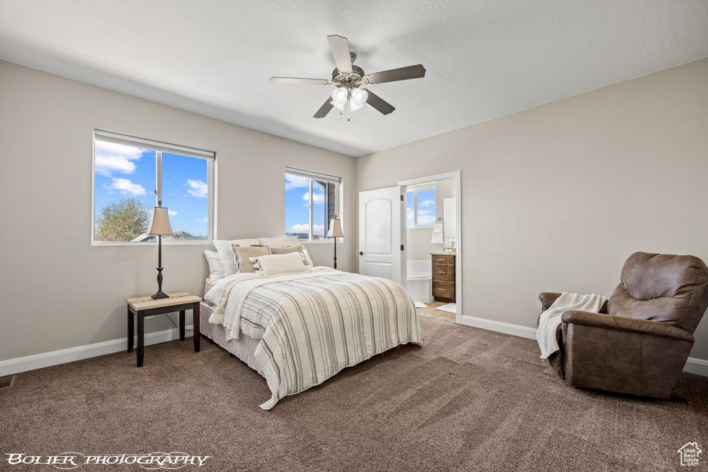 Carpeted bedroom featuring connected bathroom and ceiling fan