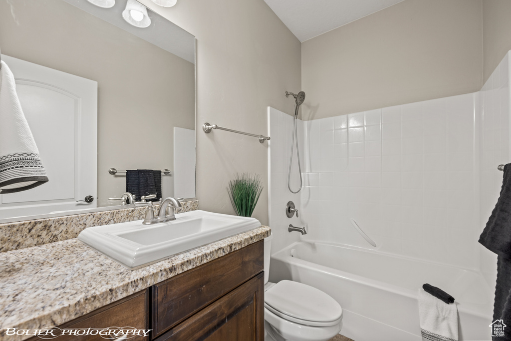 Full bathroom with vanity with extensive cabinet space, toilet, and shower / bathtub combination