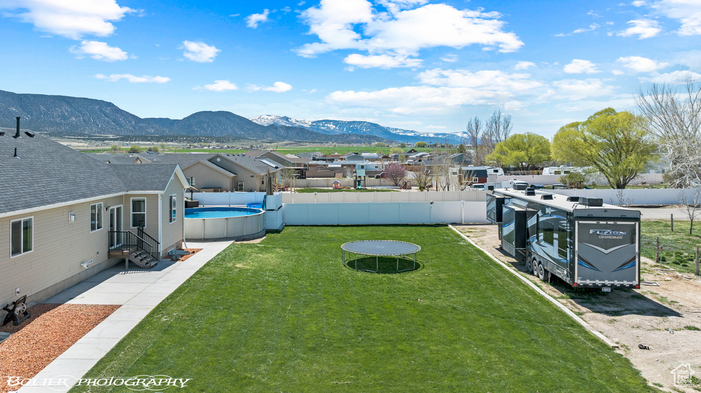View of yard featuring a fenced in pool and a mountain view
