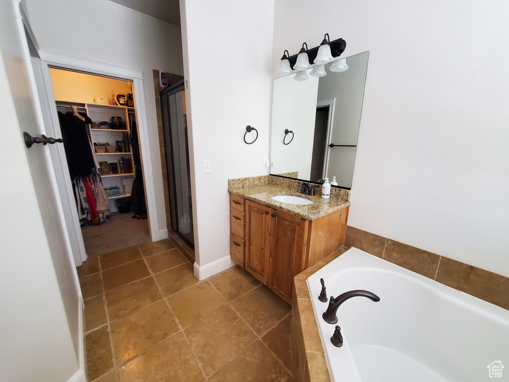 Bathroom with vanity, separate shower and tub, and tile floors