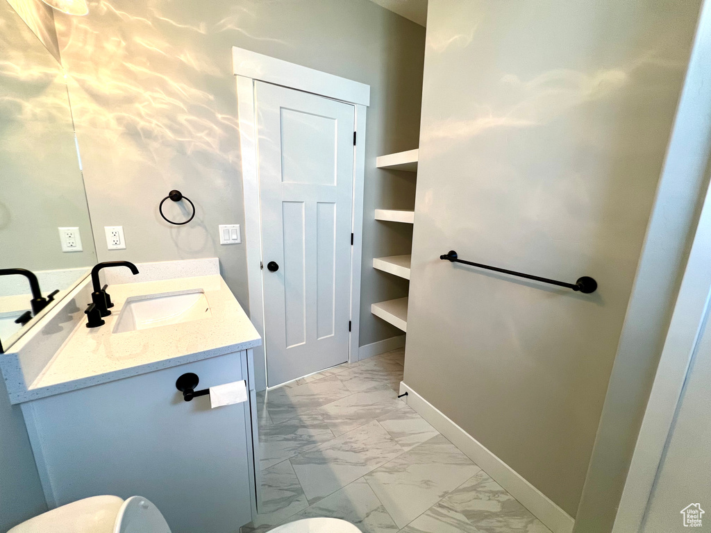 Bathroom featuring vanity, tile floors, and built in shelves