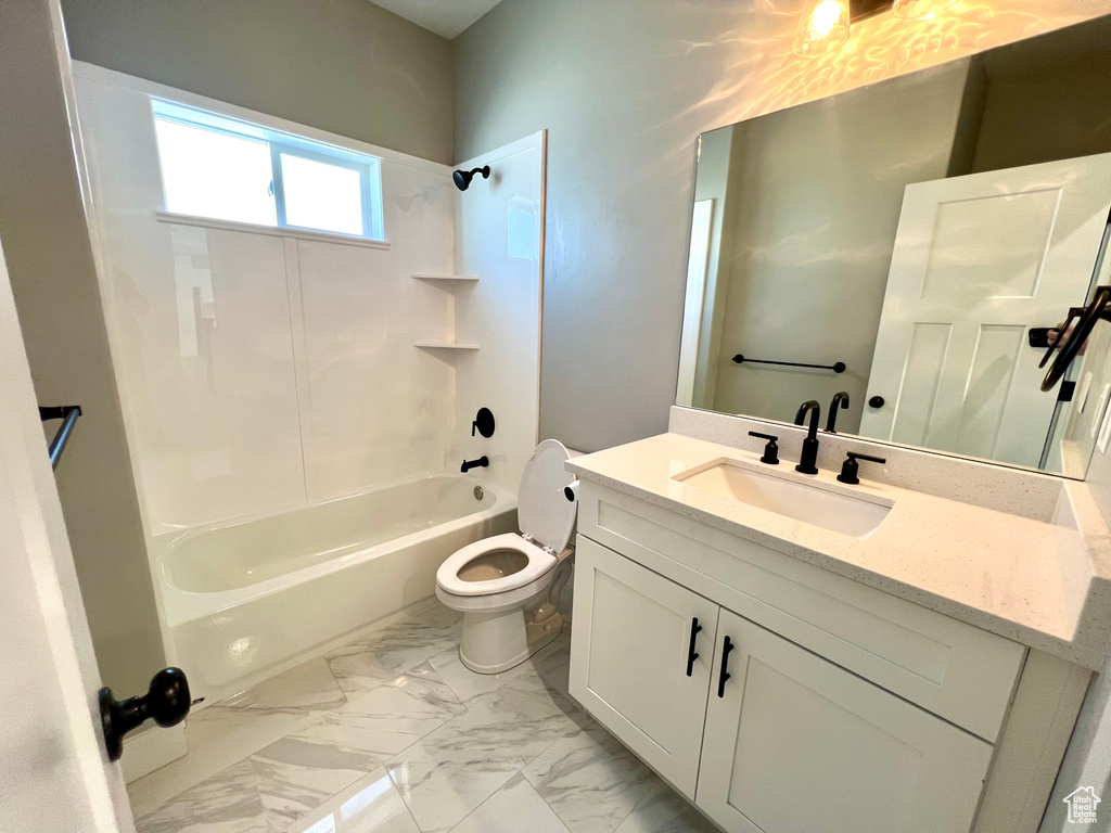 Full bathroom with oversized vanity, tile floors, toilet, and shower / washtub combination