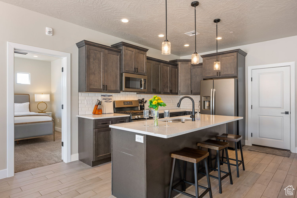 Kitchen featuring light colored carpet, sink, tasteful backsplash, and appliances with stainless steel finishes