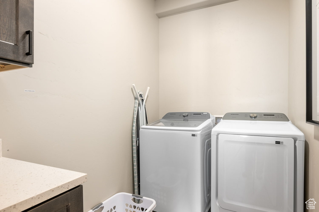 Laundry room featuring cabinets and separate washer and dryer
