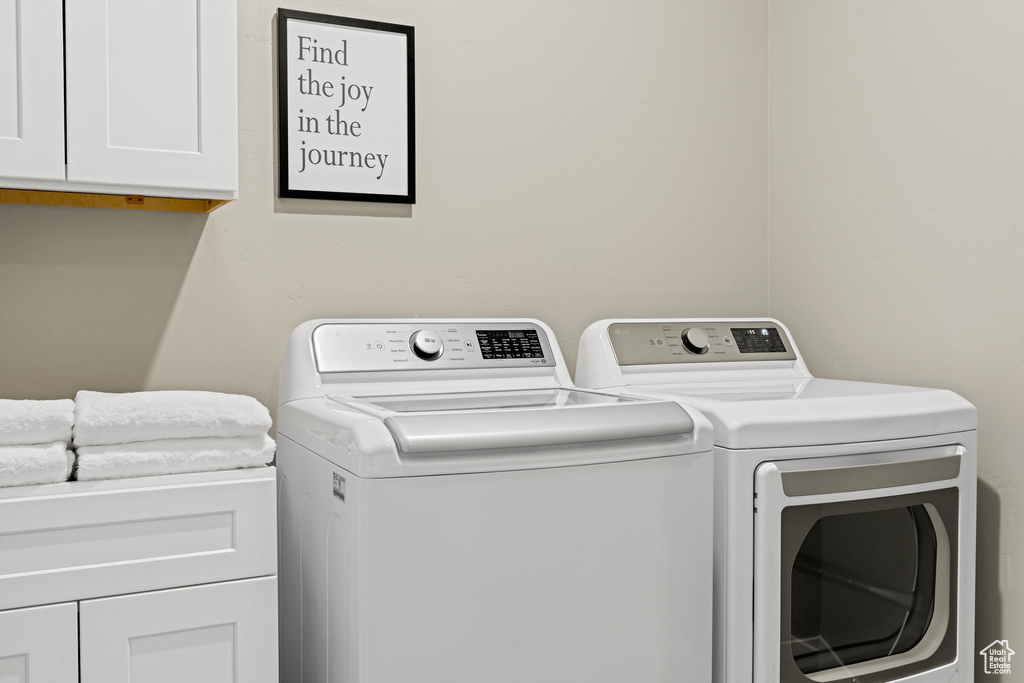 Washroom with washer and dryer and cabinets