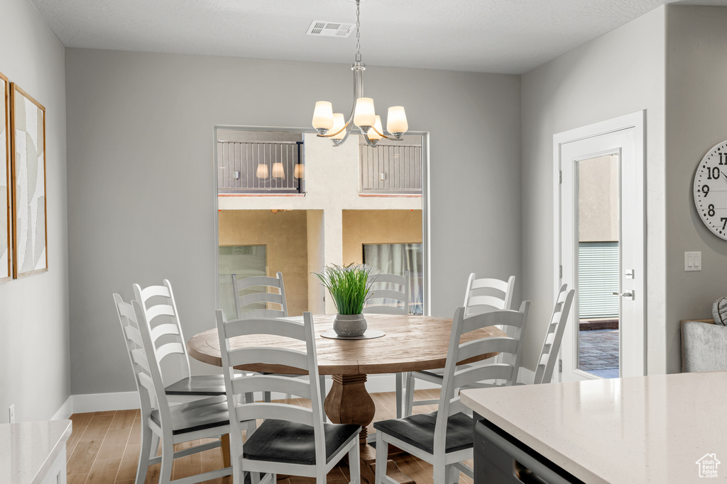 Dining space featuring an inviting chandelier and hardwood / wood-style floors