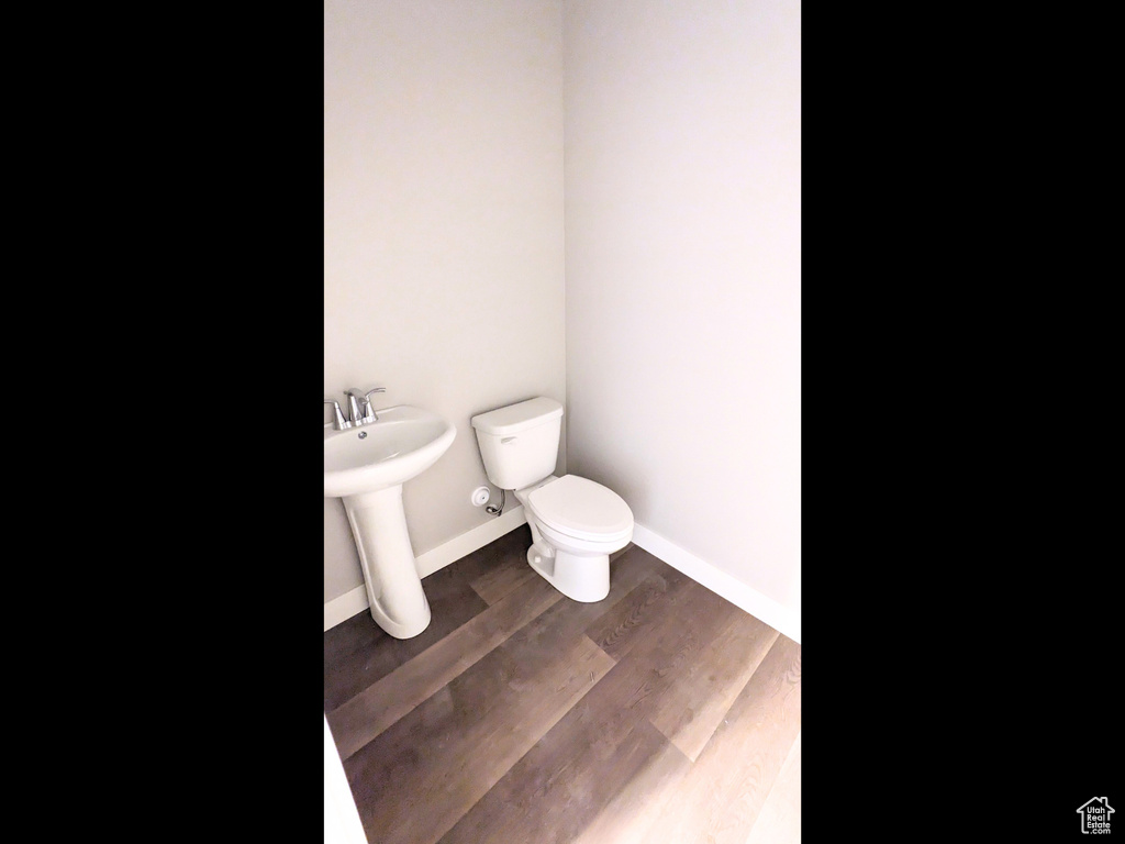 Bathroom featuring sink, wood-type flooring, and toilet