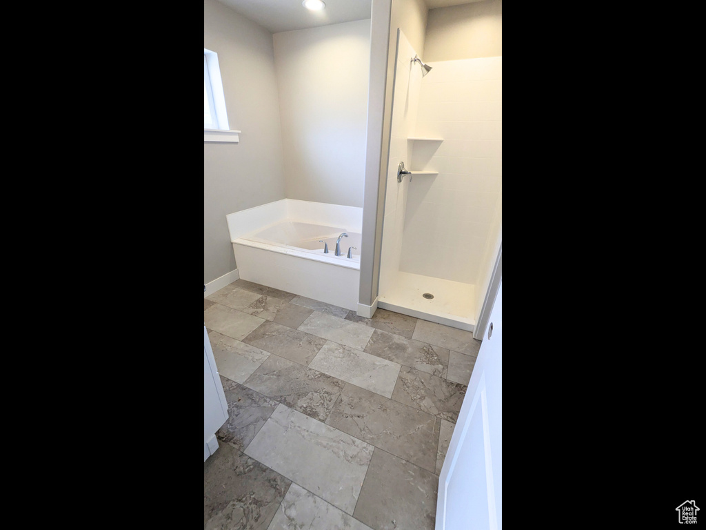 Bathroom featuring shower with separate bathtub and tile patterned floors