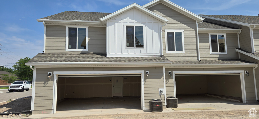 View of front of property with a garage and central AC