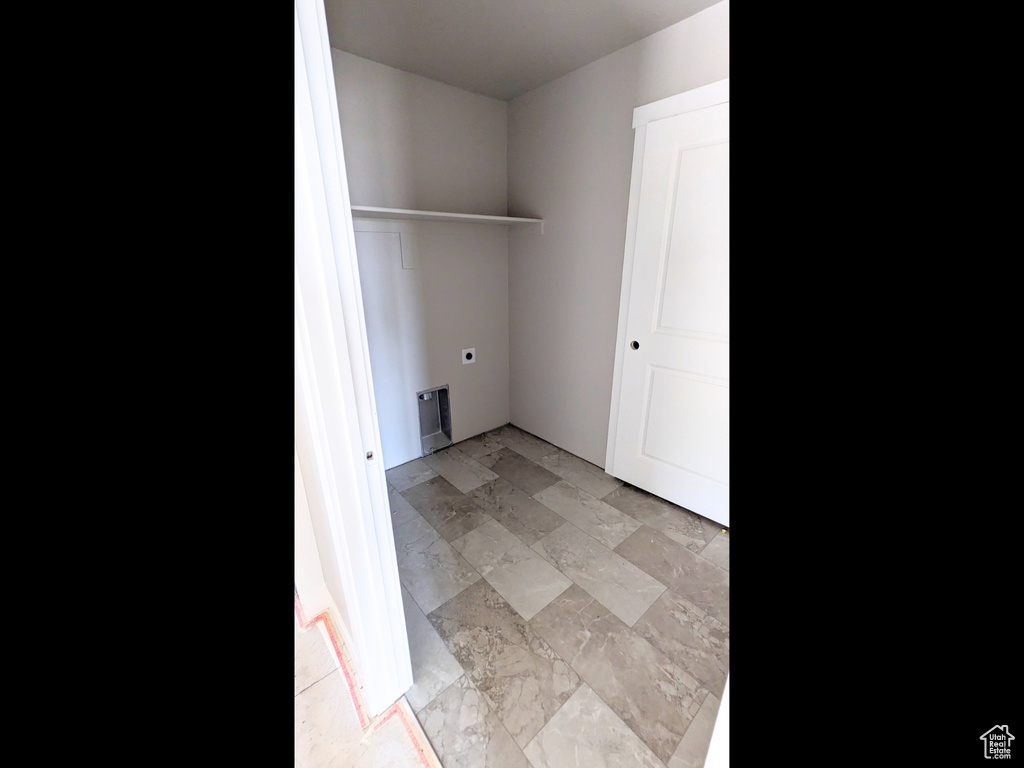 Washroom featuring hookup for an electric dryer and light tile patterned floors