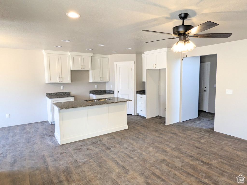 Kitchen featuring white cabinetry, dark hardwood / wood-style flooring, a kitchen island, and ceiling fan