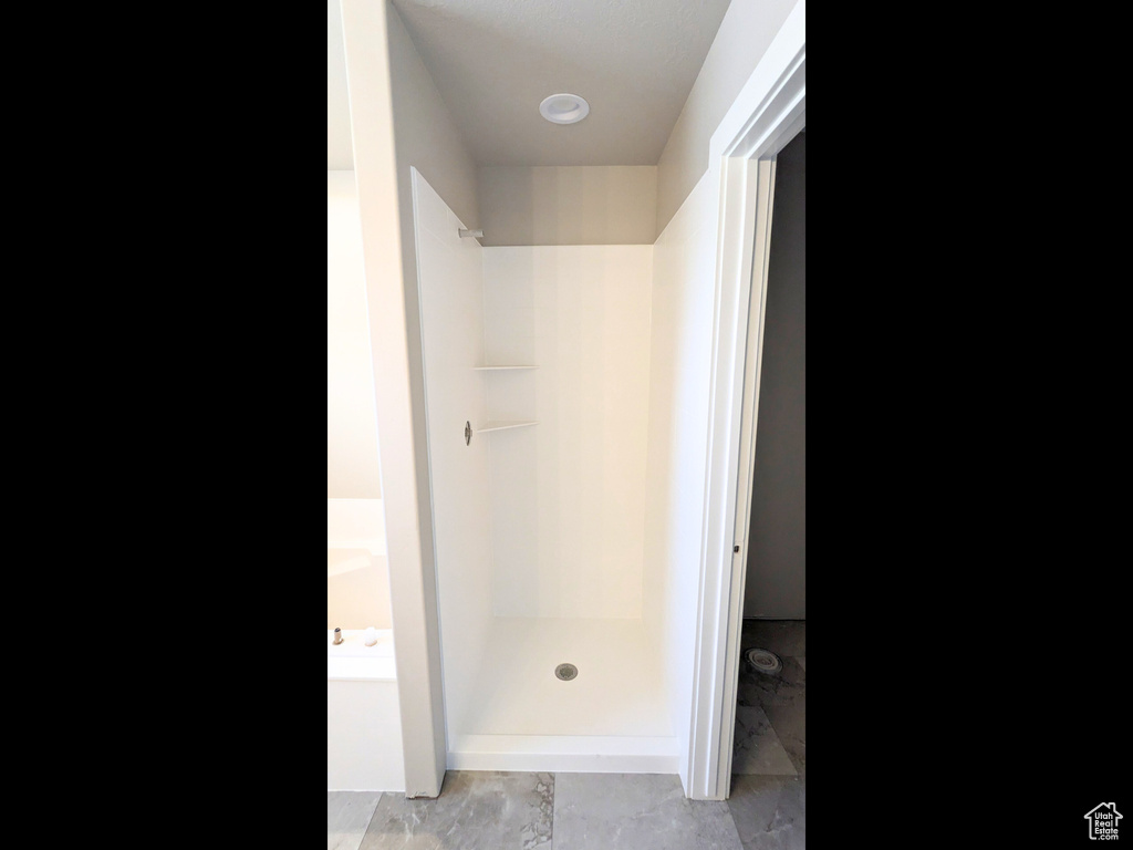 Bathroom with independent shower and bath and tile patterned flooring