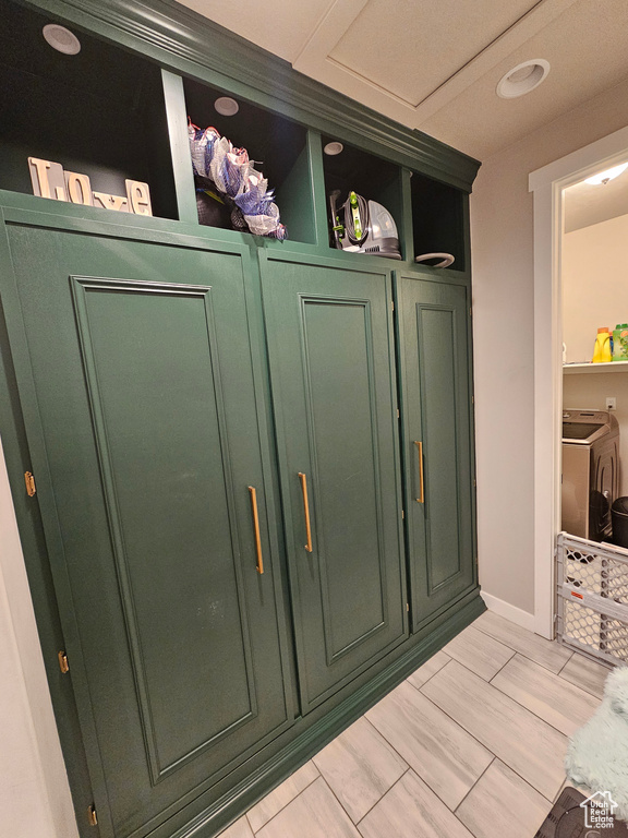 Mudroom featuring light tile floors and separate washer and dryer