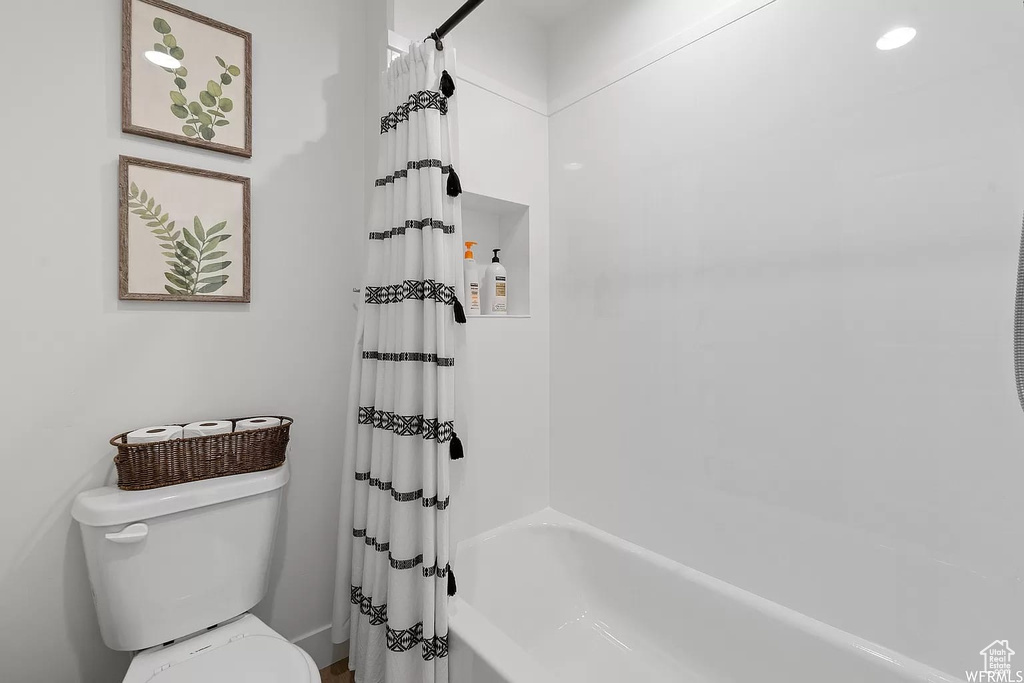 Bathroom featuring shower / tub combo and toilet
