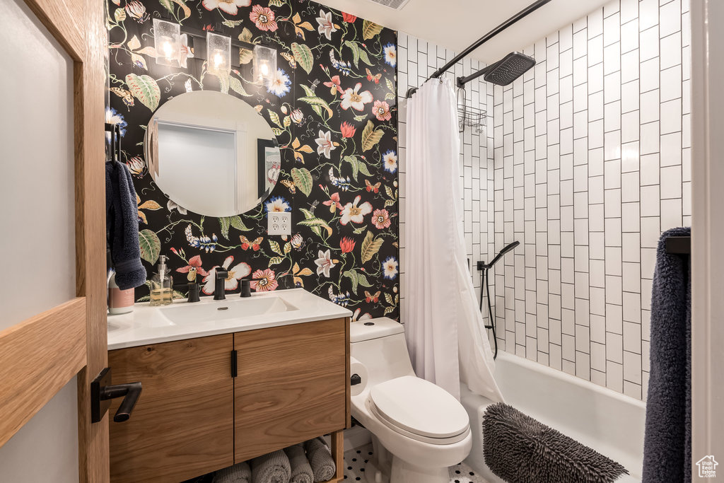 Full bathroom with shower / tub combo, toilet, tile floors, and vanity