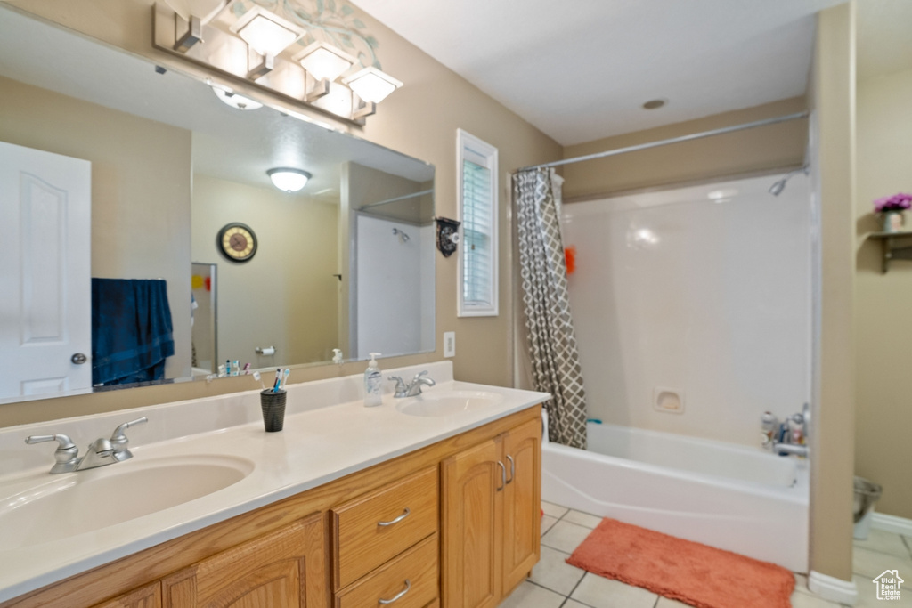 Bathroom with tile flooring, shower / bath combo with shower curtain, and dual vanity
