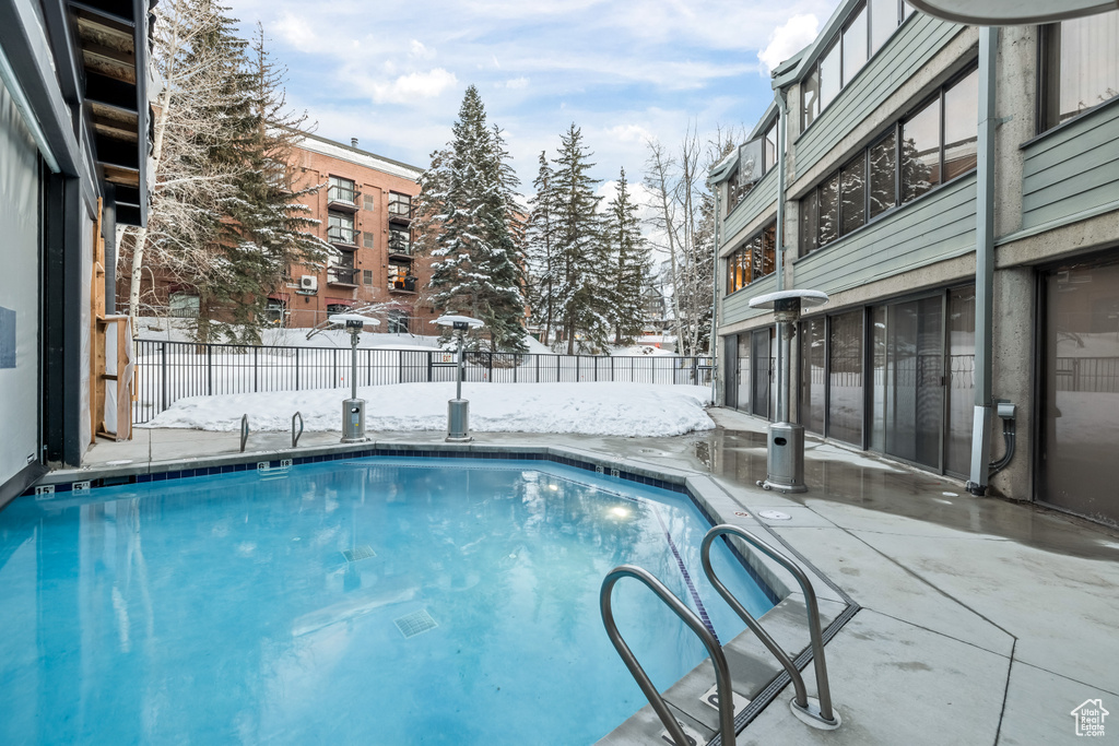Snow covered pool with a patio area