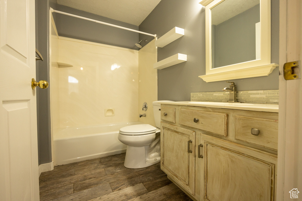 Full bathroom with toilet, vanity, hardwood / wood-style floors, and shower / tub combination