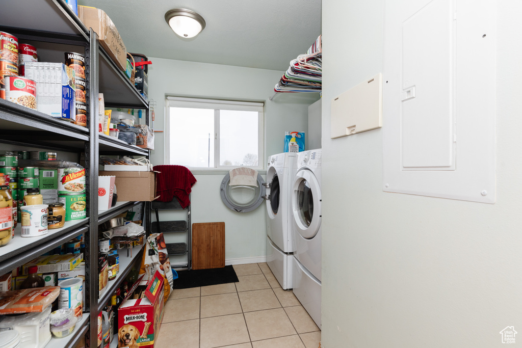 Washroom featuring light tile floors and washing machine and clothes dryer