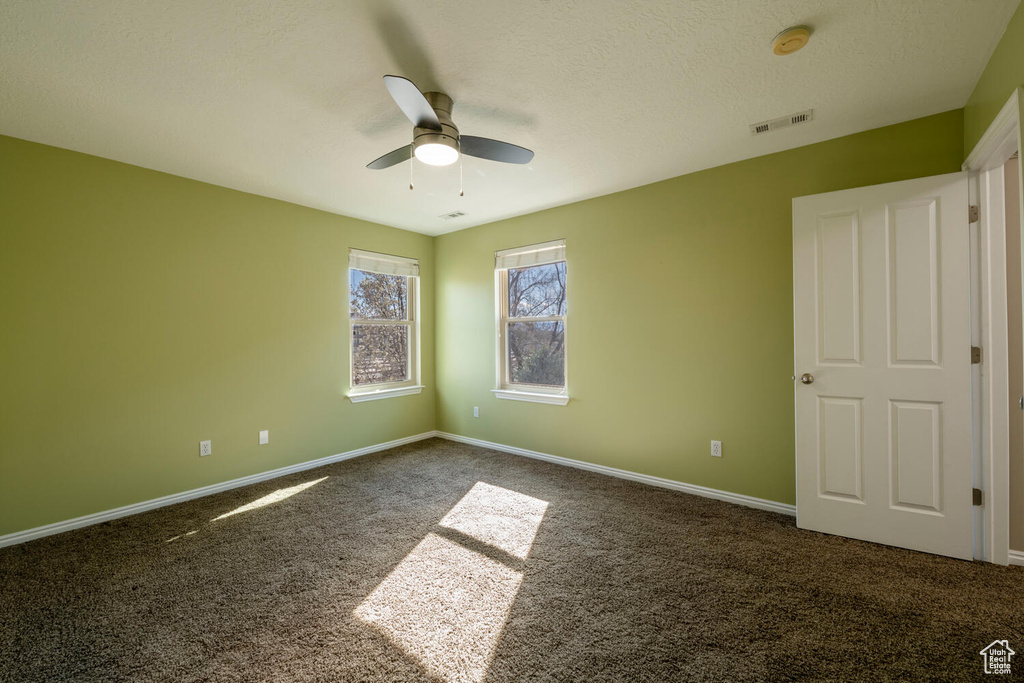 Empty room with ceiling fan and carpet