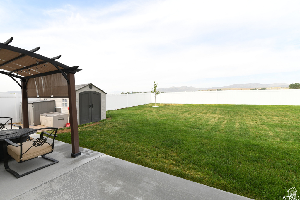 View of yard with a patio, a storage shed, a pergola, and a water view
