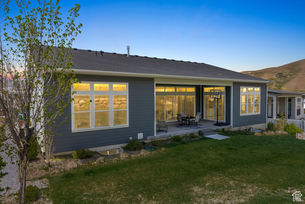 Rear view of house with a patio and a yard