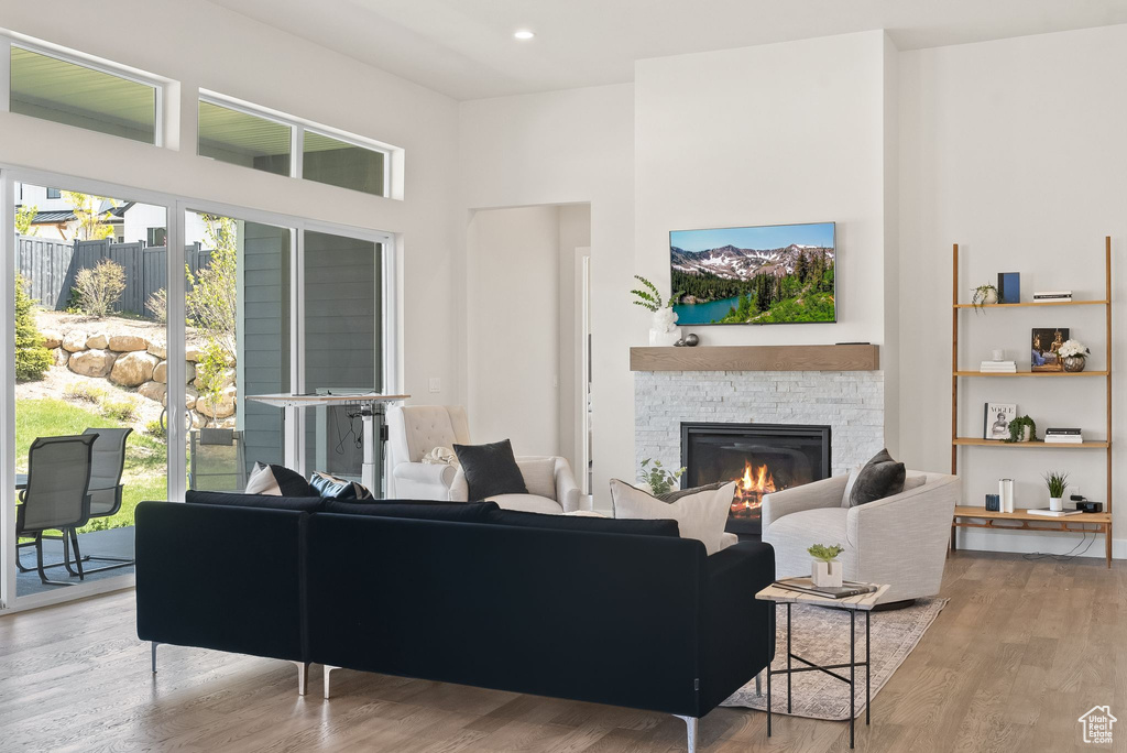 Living room with hardwood / wood-style flooring and a stone fireplace