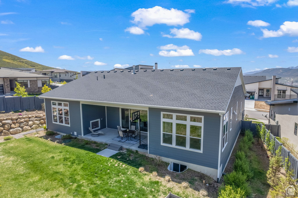 Back of house with a yard and a patio area